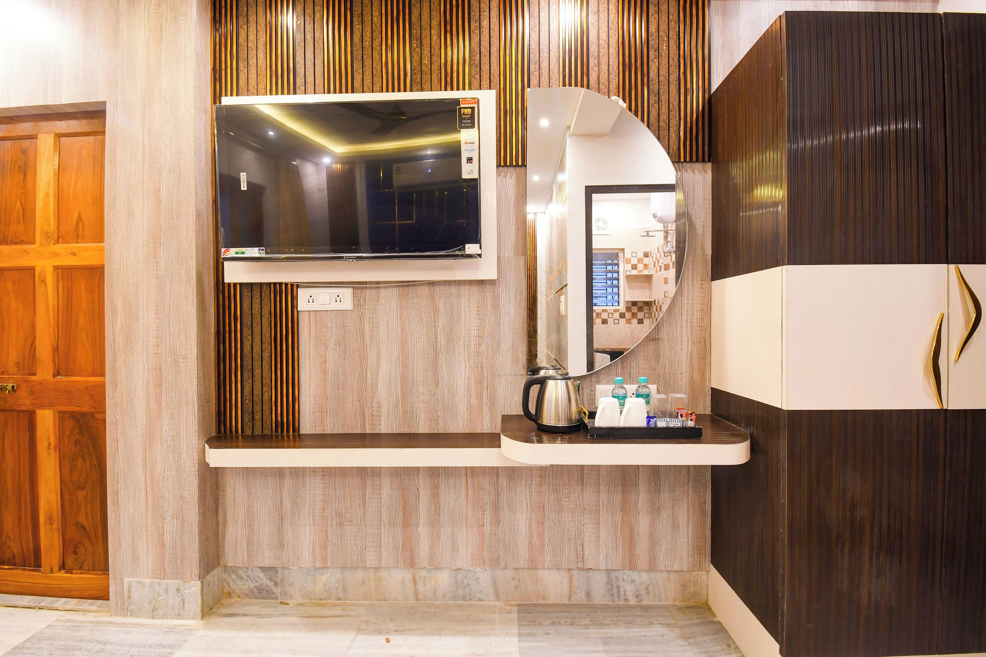 Une salle de bain moderne équipée d’un téléviseur encastré, d’un miroir et d’une machine à café posée sur le comptoir.