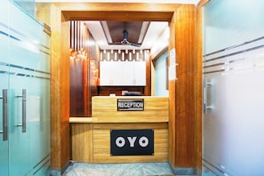 En receptionsdisk med et skilt, der står 'RECEPTION' og 'OYO'.