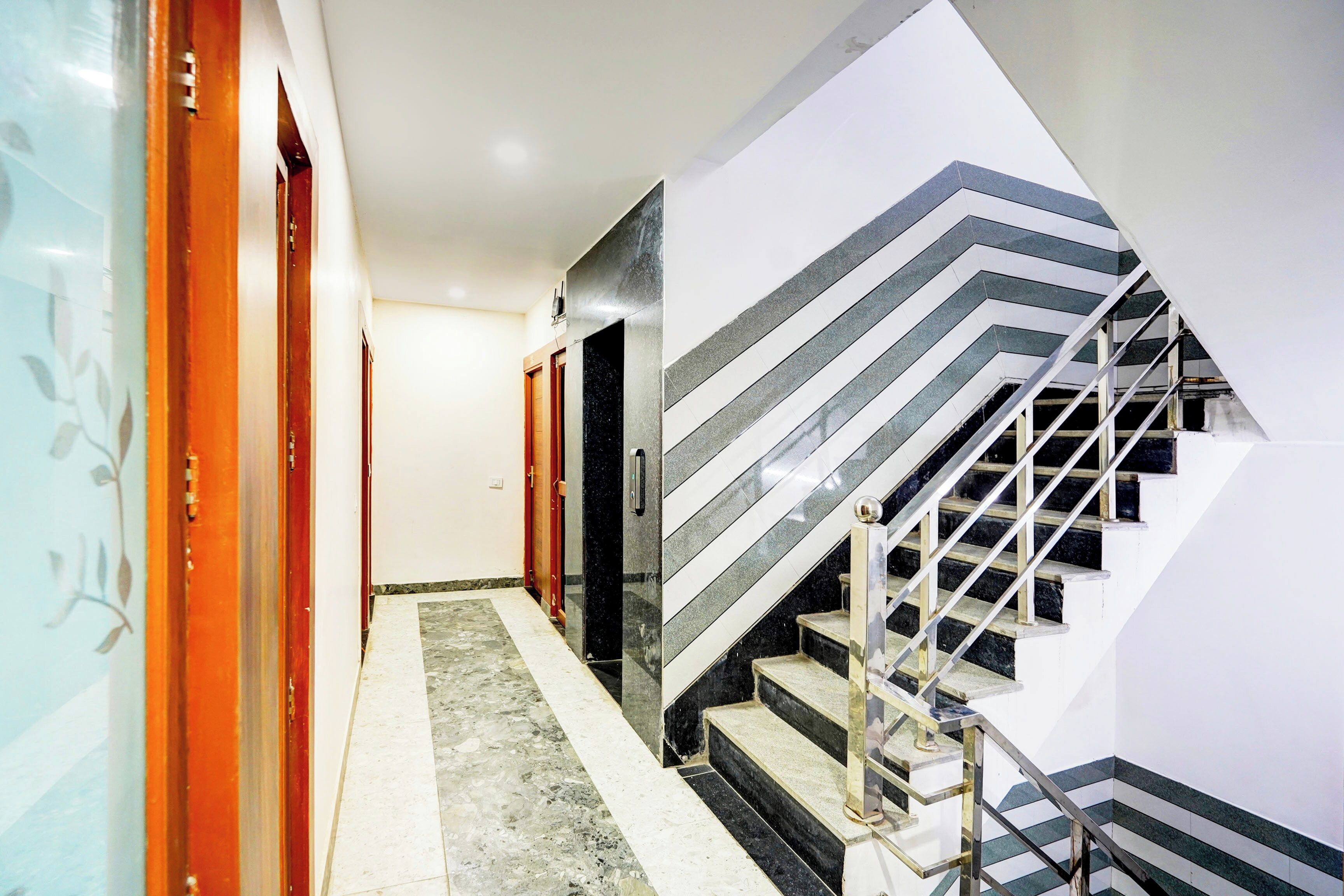Un pasillo que conduce a una escalera con un diseño geométrico distintivo.