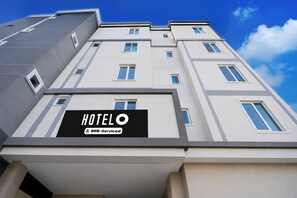 Un edificio de hotel con múltiples ventanas y un letrero que indica que cuenta con servicios OYO.