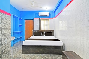 A bedroom with a bed, a wardrobe, a door, and a window with bars. - Hotel O New Cuttack Guest House (Cuttack)