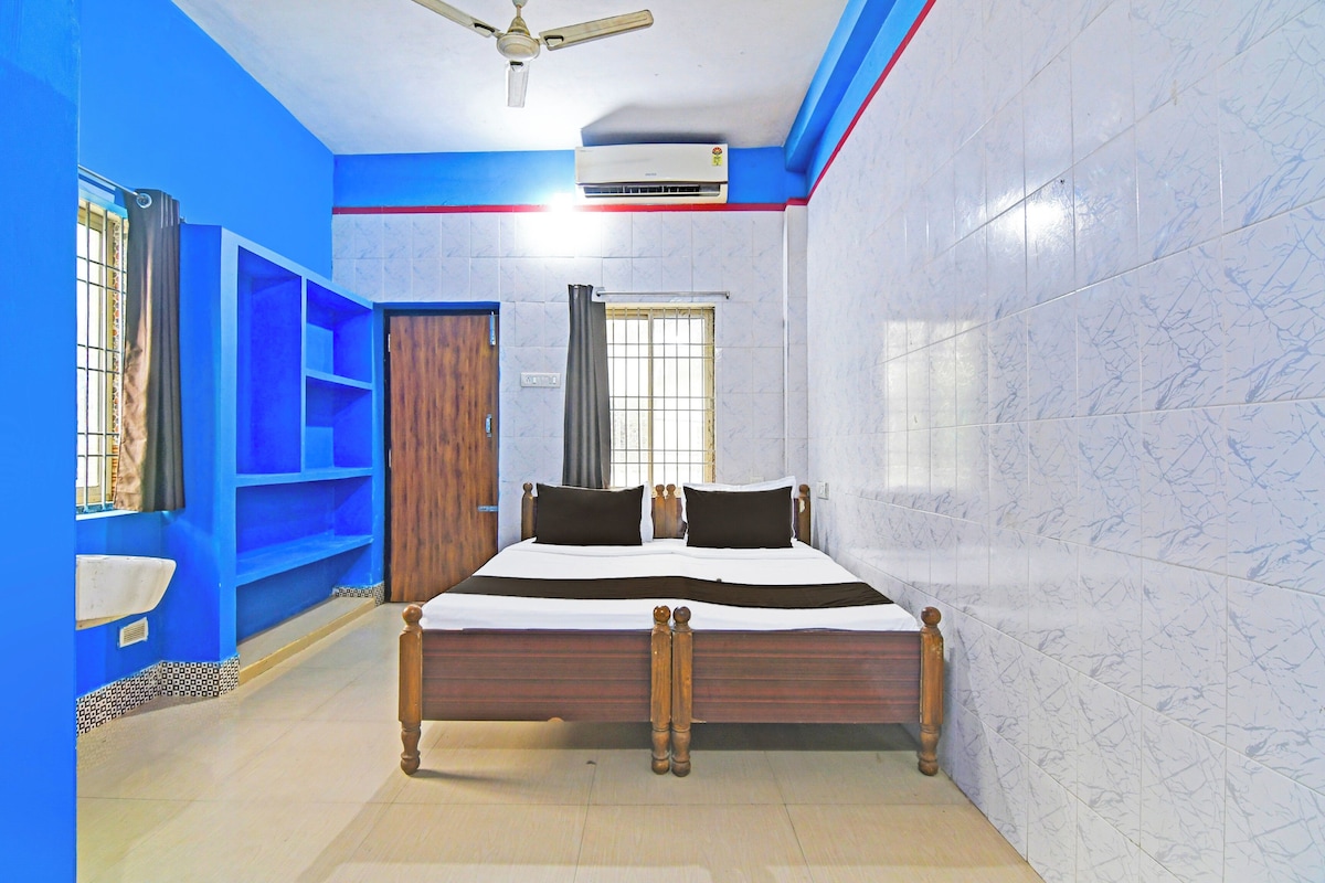 A bedroom with a bed, a wardrobe, a ceiling fan, and an air conditioning unit.