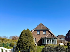 A two-story house with a pitched roof, a conservatory, and a well-maintained garden. - Holiday Home in Nieblum With Swimming Pool (Nieblum)