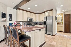 A kitchen with a central island, a refrigerator, and a microwave. - Ski In/Ski Out Access to Giant Steps (Brian Head)