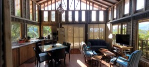 A spacious room with a large dining table, a sofa, and a television. - LA CABAÑA EN The GUADUAL (San Antonio Del Tequendama)