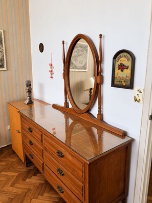 A wooden dresser with drawers and a mirror, a striped wall, and a framed picture. - New Listing (Montevideo)