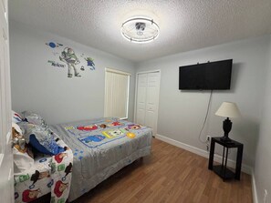 A bedroom with a bed, a TV, a lamp, and a ceiling fan. - Cozy Home minutes from Disney (Davenport)