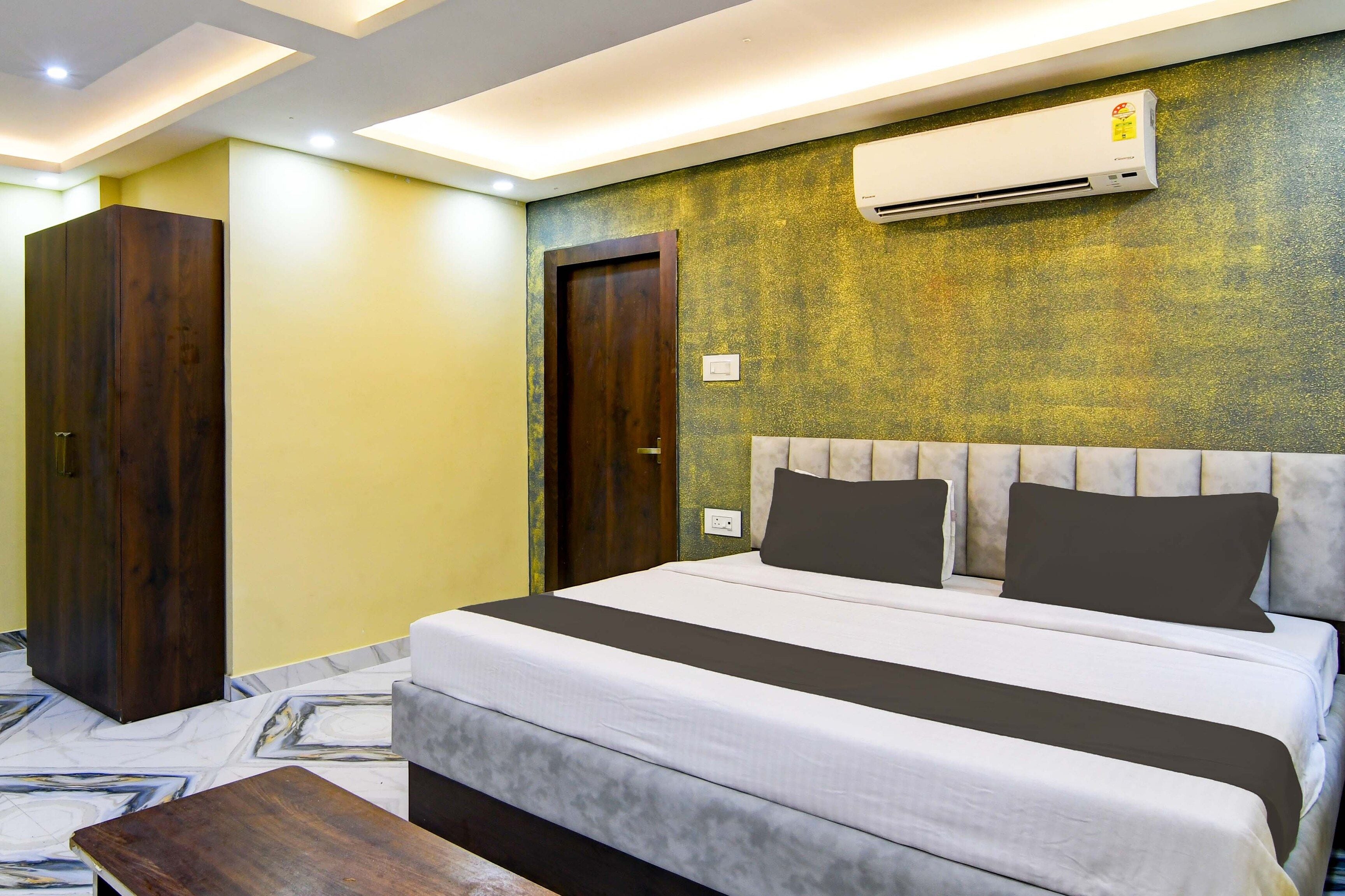 Un dormitorio moderno con una cama, un armario de madera y un equipo de aire acondicionado.