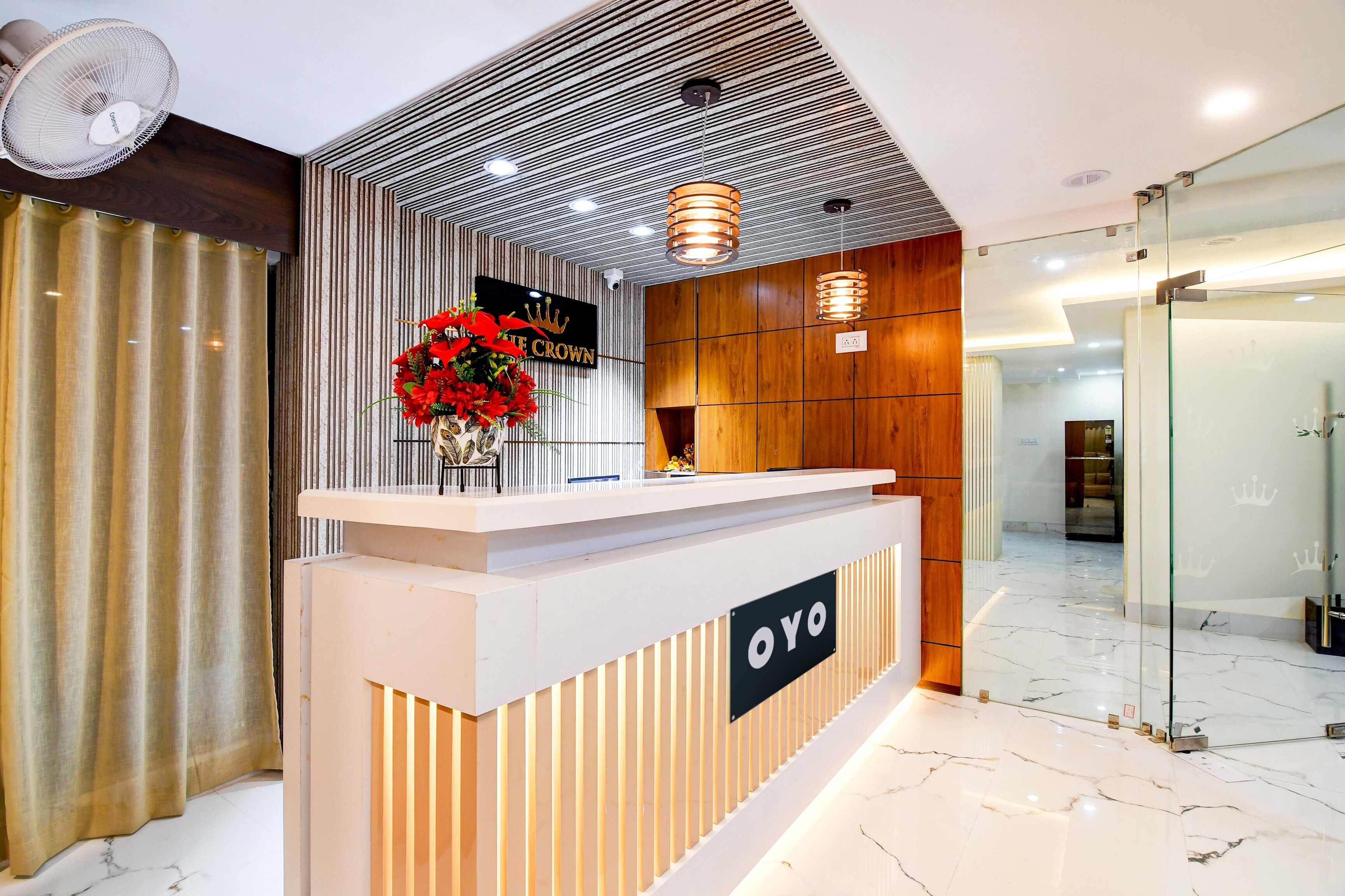 A reception desk with a sign reading 'OYO' and a decorative flower arrangement.