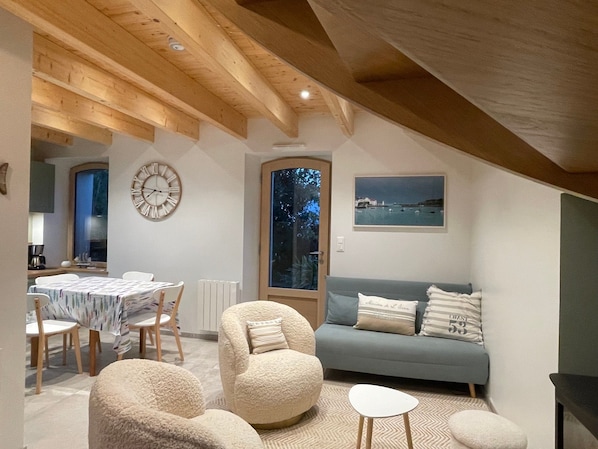 Un dormitorio tipo loft acogedor con comedor, un ventanal con vistas y un techo de madera rústica.