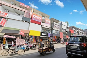 A street view with multiple storefronts, including a hotel and a nail salon.
