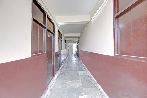 A corridor with doors on both sides, leading to rooms.