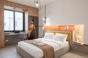 Una habitación de hotel moderna con cama, escritorio y ventana.