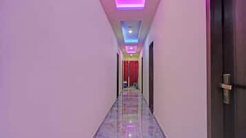 A hallway with a marble floor and a ceiling with recessed lighting.