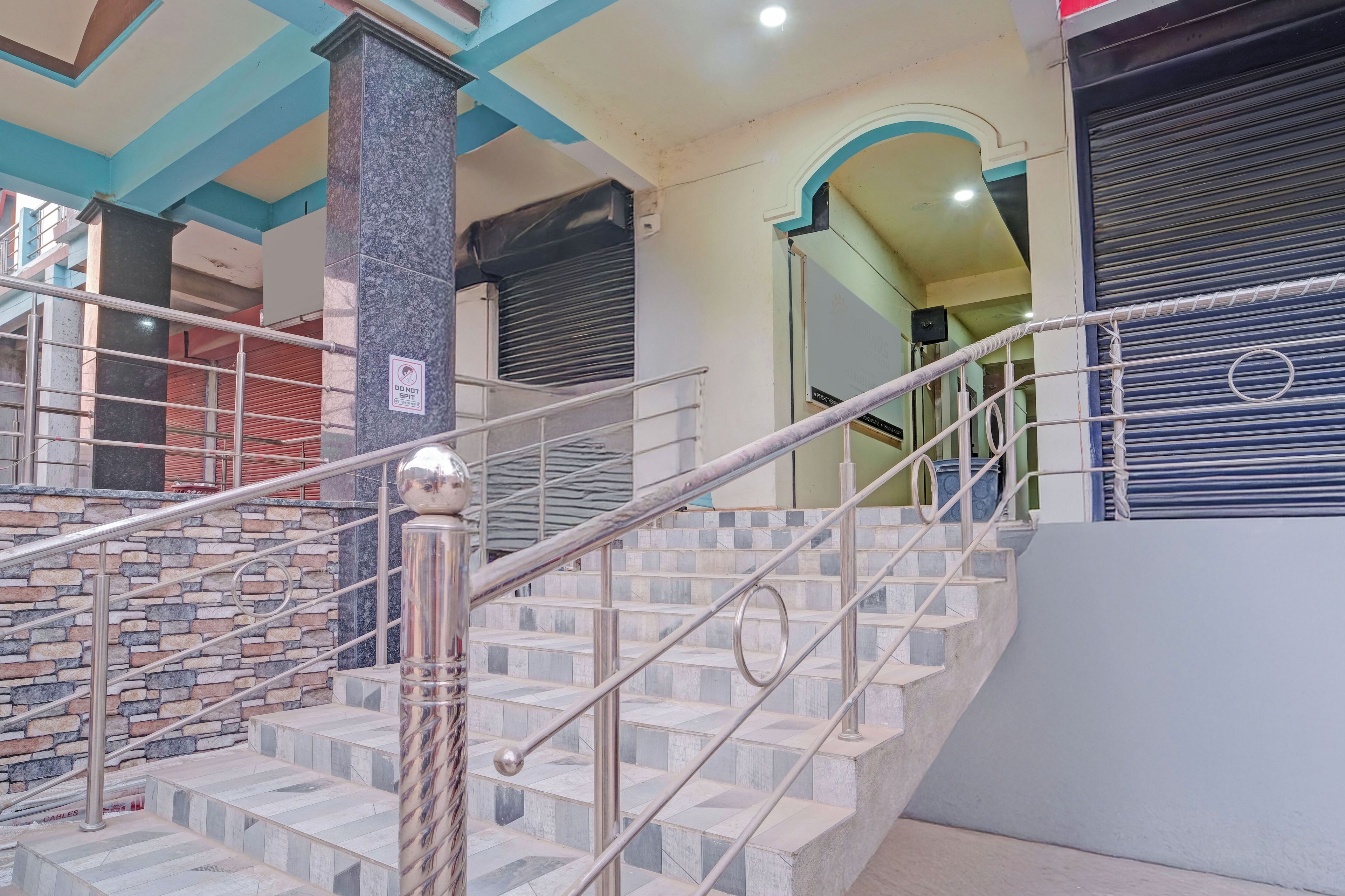 Una escalera con barandillas de metal y peldaños de piedra, que conduce a un piso superior.
