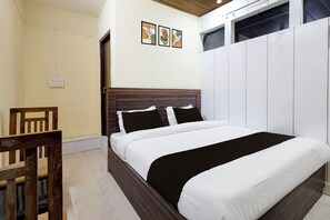 Ein Schlafzimmer mit einem hölzernen Bettgestell, weißer Bettwäsche und einem Holzstuhl.