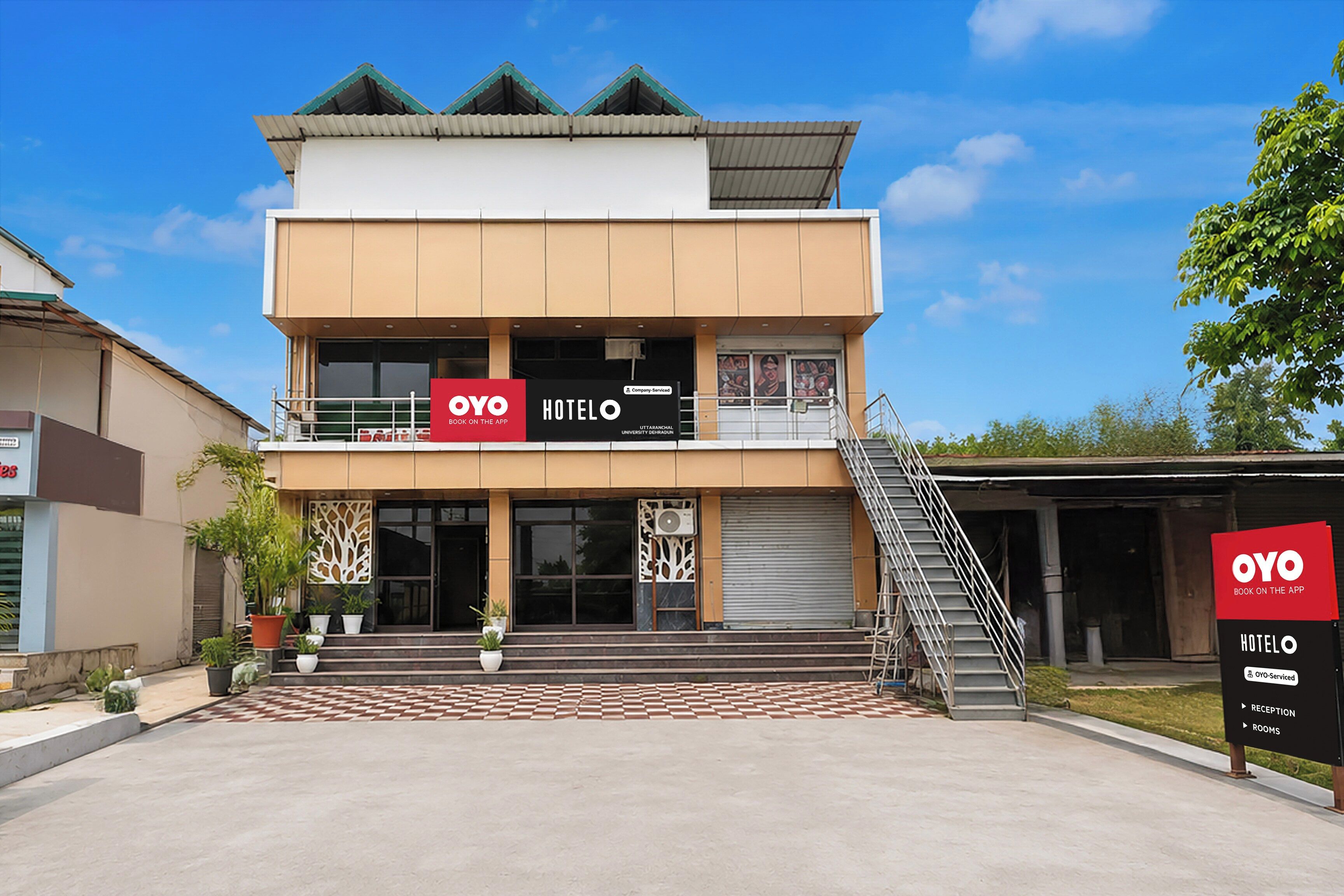 Ein zweistöckiges Hotel im modernen Design, mit einem gut sichtbaren 'OYO HOTEL' Schild.