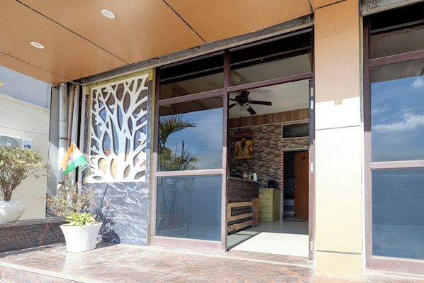 A building entrance with a glass door, a ceiling fan, and a decorative tree cutout.