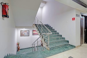 A staircase with metal railings and marble steps, leading to a dining area marked by a red sign. - Super Collection O Dhanbad Railway (Dhanbad)