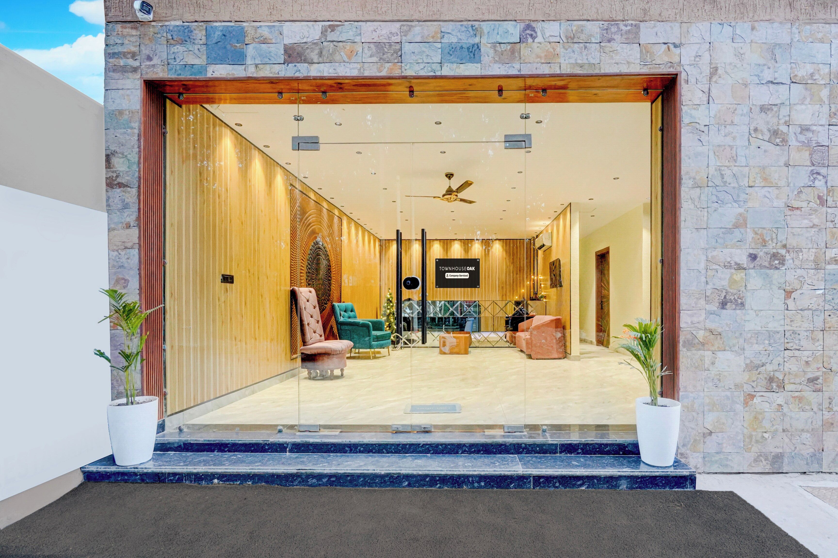 Fachada de hotel de piedra, con mostrador de recepción y zona de estar.