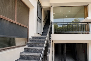 A staircase leading to a second-floor balcony with a glass railing.