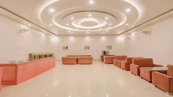 A spacious lobby with a central seating area, a reception desk, and a modern ceiling design.