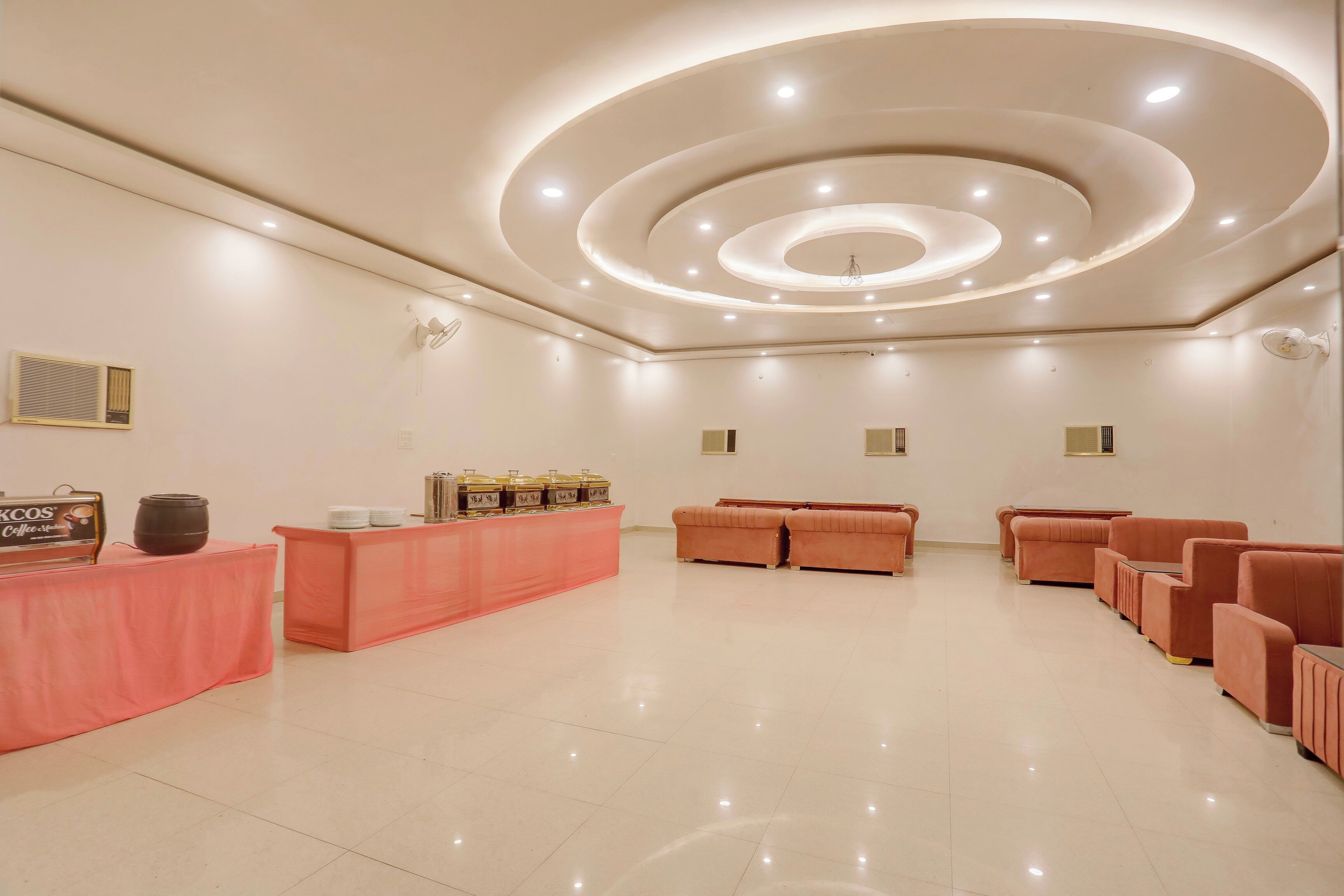 A reception area with a counter, seating, and a modern ceiling design.