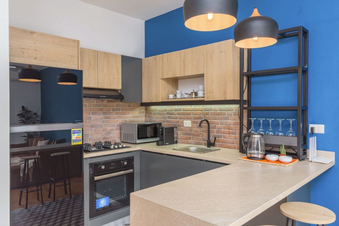 Una cocina moderna con una isla central, microondas, estufa a gas y un lavamanos.