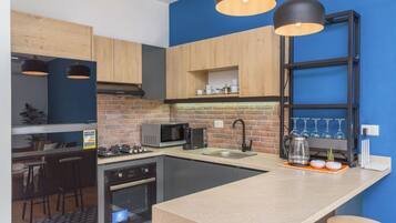 Una cocina moderna con una isla central, microondas, estufa a gas y un lavamanos.