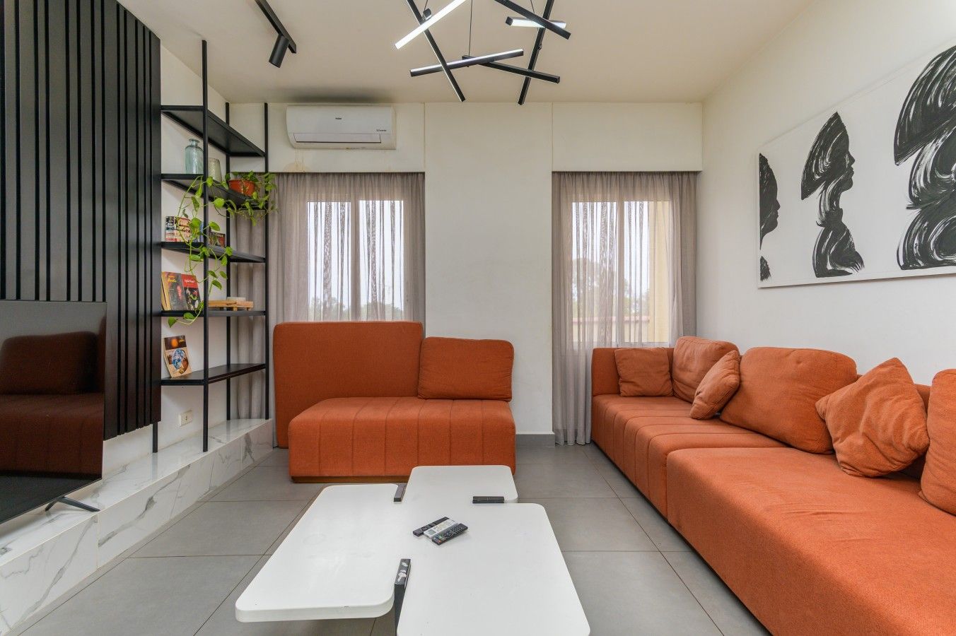 Una sala de estar moderna con un conjunto de sofá, una mesa de centro y un televisor.
