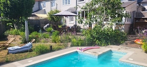 A backyard with a swimming pool, lounge chairs, and a barbecue area. - Comfortable country retreat in a rural village. Pet and family friendly! (White Colne)