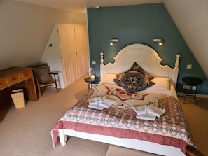Ein Schlafzimmer mit einem Bett, einem Schreibtisch und einem Stuhl.