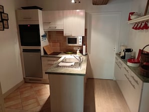 A compact kitchen with a microwave, sink, and a small island. - New Listing (Cosne-Cours-sur-Loire)