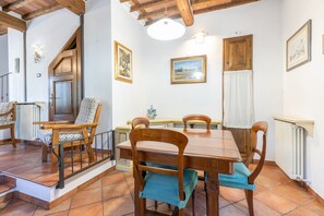 A dining area with a wooden table and chairs, a staircase, and a radiator. - A cozy and elegant 60-square-meter apartment spread over two floors, ideal for three guests (please note: no elevator; there are internal and external steps). This independent townhouse, located within a courtyard, is situated in the San Concordio distri (Lucca)