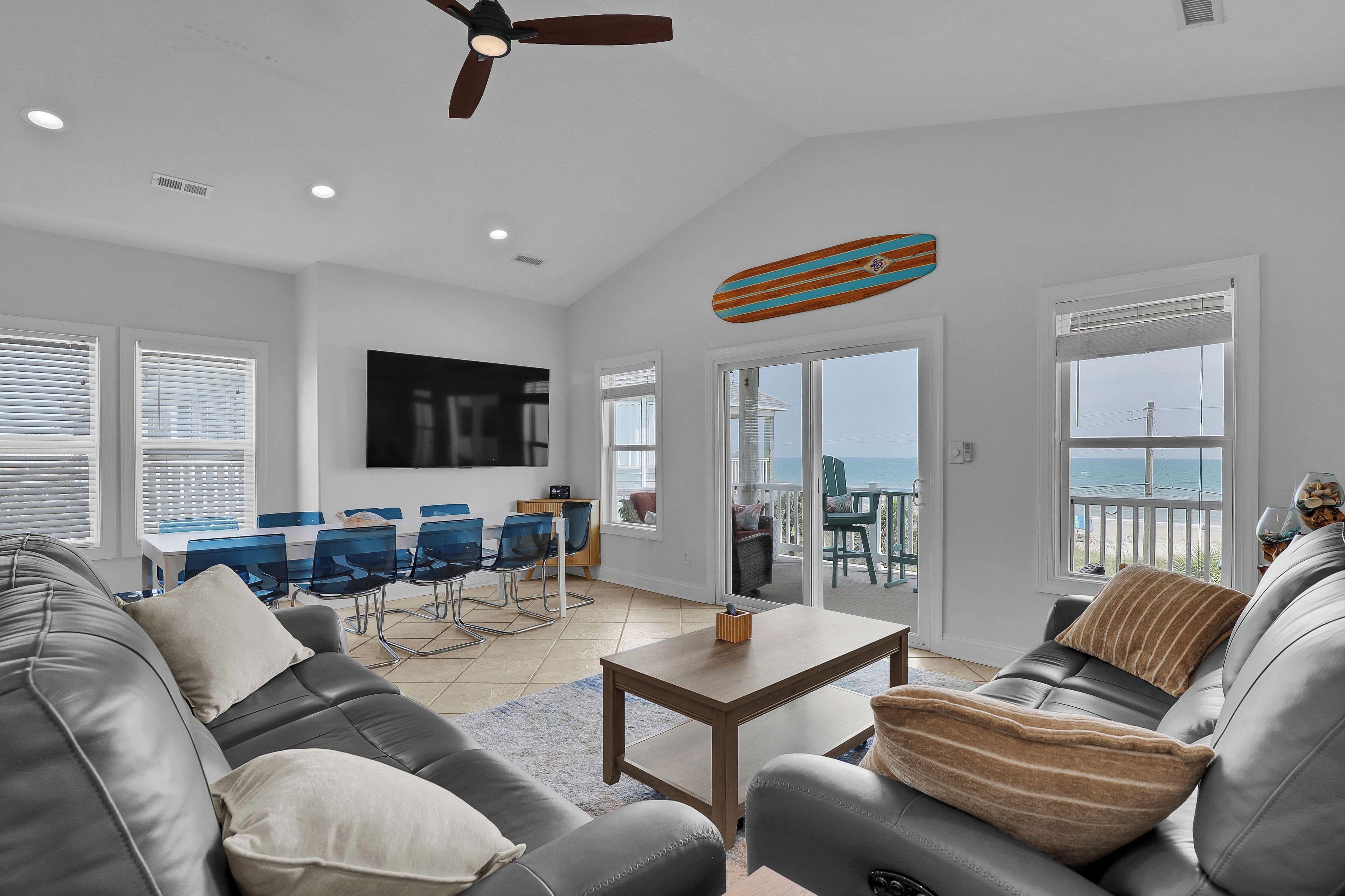 A modern living room with a sofa, coffee table, and a TV mounted on the wall.