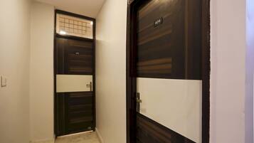 Un pasillo con una puerta de madera oscura numerada 404, una pared de color claro y un suelo de baldosas.