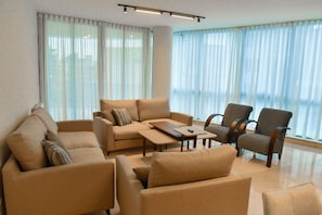 A modern living room with a sofa, armchairs, and a coffee table. - Sodeco Ashrafieh by Stayinn (Beirut)