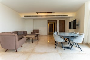 A modern living room with a sofa, a coffee table, and a dining area with a table and chairs. - Sodeco Ashrafieh by Stayinn (Beirut)
