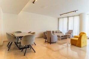 A modern living room with a dining area, a sofa set, and a yellow armchair. - Sodeco Ashrafieh by Stayinn (Beirut)