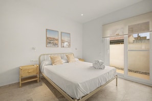 A bedroom with a bed, two nightstands, a window with a view, and two wall-mounted pictures. - Lo Freixer Holiday Home — pool, tranquility, and the river steps away in Deltebre (Deltebre)