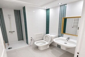 A modern bathroom with a shower, toilet, and sink. - Cozy & Bright Aouina Apartment (Site archéologique de Carthage)