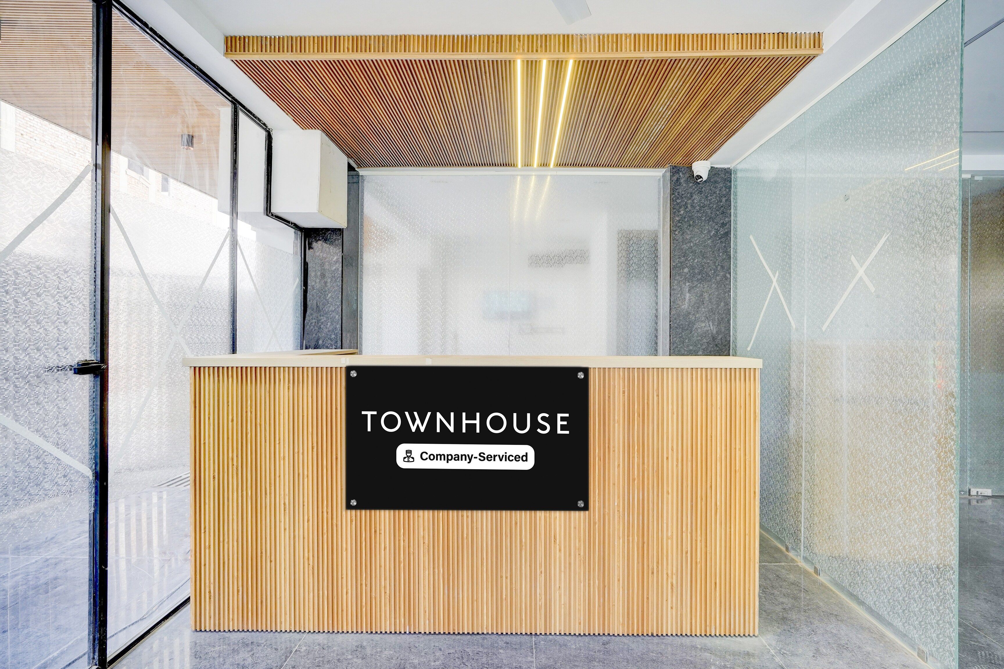 Una mesa de recepción con un letrero que dice 'TOWNHOUSE Company-Serviced'.