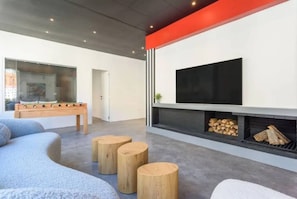 A modern living room with a flat-screen TV, a fireplace, and a foosball table. - Pasteur 627 Gemmayze by Stayinn (Beirut)