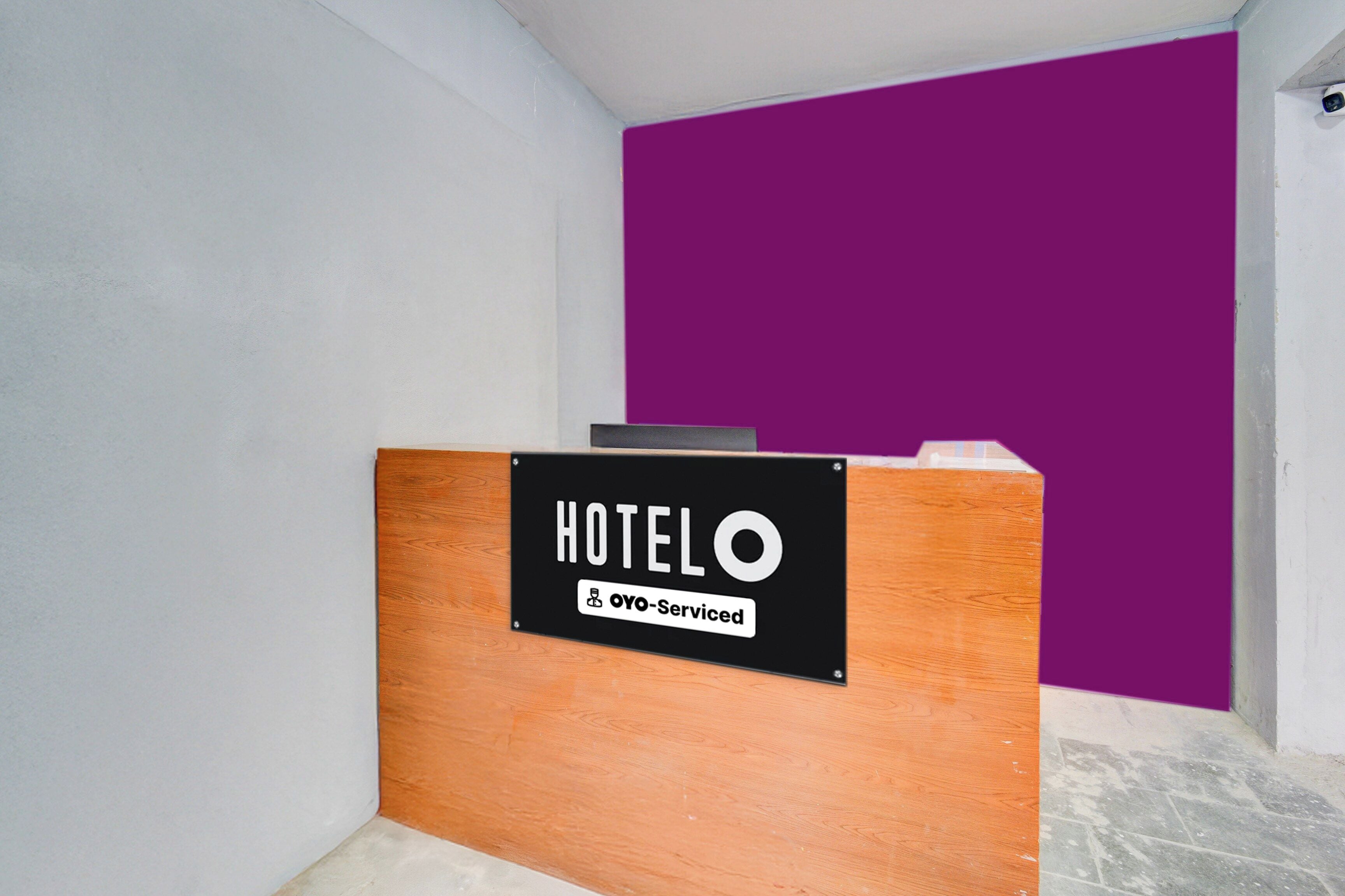 A reception desk with a sign indicating it is serviced by OYO.