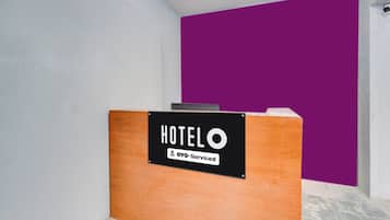 A reception desk with a sign indicating it is serviced by OYO.