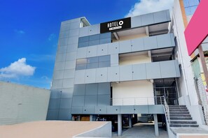 Un moderno edificio de hotel con un cartel que dice 'HOTELO' y 'OYO-Serviced'.