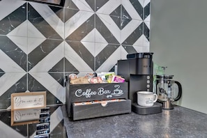 A coffee station with a coffee maker, a coffee box, and a mug on a countertop. - The W Retreat • Sauna • Hot Tub • 2 King Suites (Sevierville)