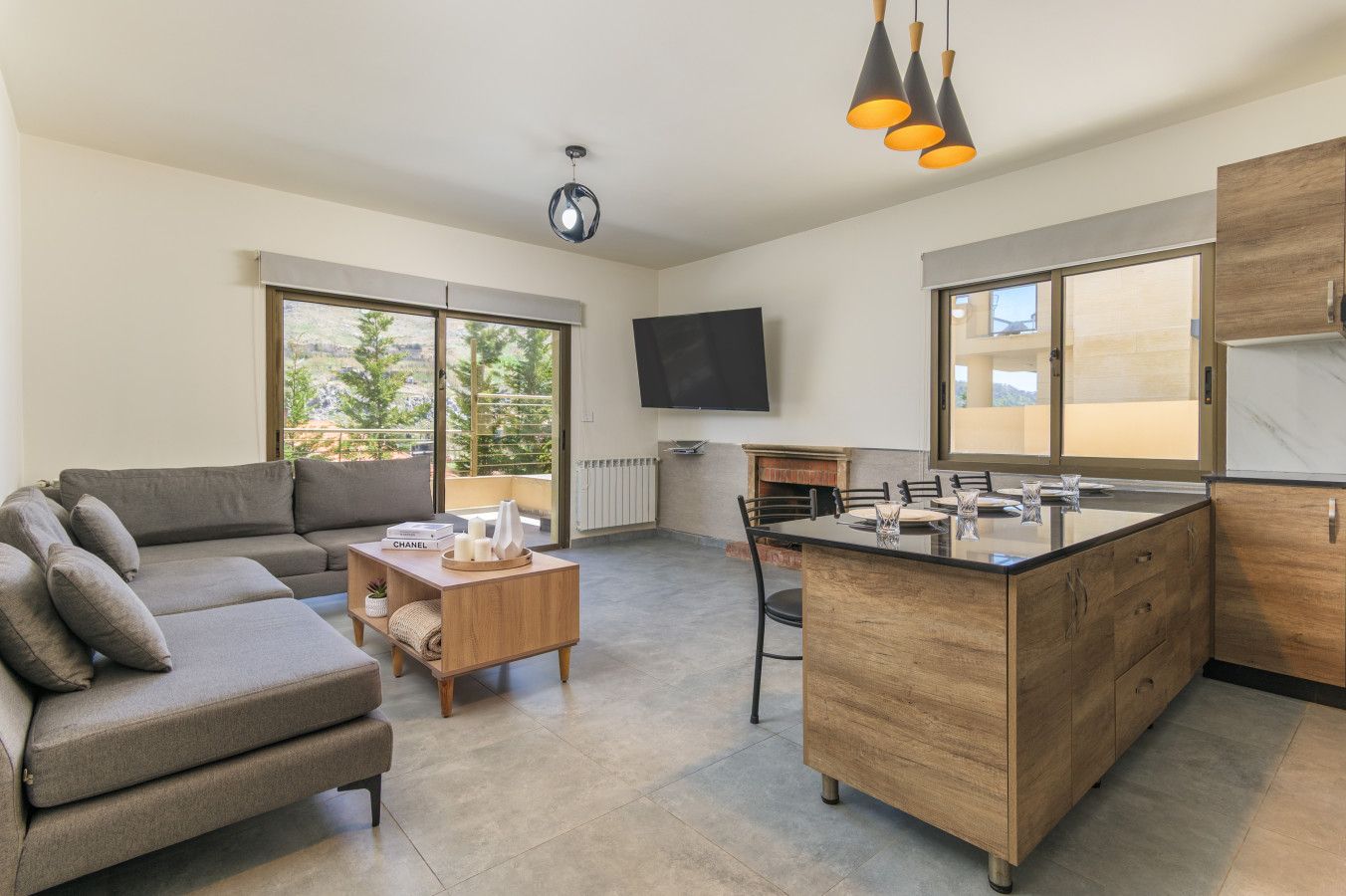 Un espacio habitable moderno con sofá, mesa de centro e isla de cocina con pileta.