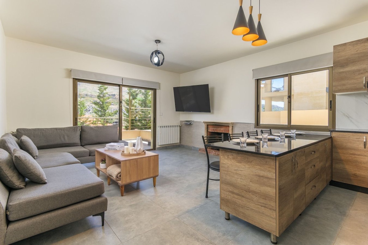 A modern living space with a sofa, coffee table, and a kitchen island with a sink.