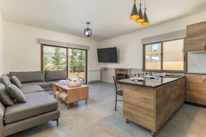 A modern living space with a sofa, coffee table, and a kitchen island with a sink.
